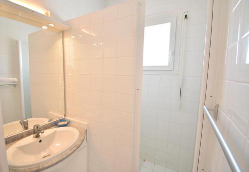 une salle de bain blanche avec un lavabo et une douche dans l'établissement Ben et sou - Hossegor appartement avec agréable terrasse au premier étage d'une villa, à Soorts-Hossegor
