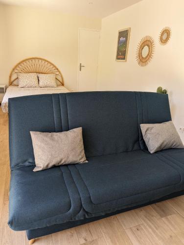 - un canapé bleu dans une chambre avec un lit dans l'établissement Studio cosy à 200m de la plage de Fabregas, à La Seyne-sur-Mer