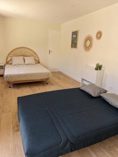 une chambre avec deux lits et un miroir au mur dans l'établissement Studio cosy à 200m de la plage de Fabregas, à La Seyne-sur-Mer