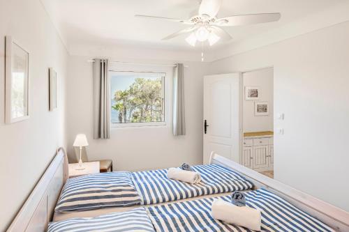 une chambre avec deux lits et un ventilateur de plafond dans l'établissement Charming villa in LES ISSAMBRES with SEA VIEW and swimming pool, aux Issambres