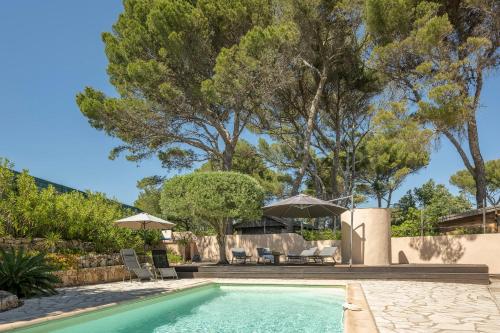 une piscine avec chaises et parasols dans une cour dans l'établissement Charming villa in LES ISSAMBRES with SEA VIEW and swimming pool, aux Issambres