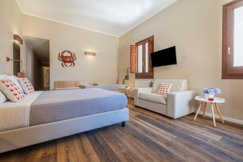 a bedroom with a bed and a couch and a tv at Salamureci Camere in Trapani