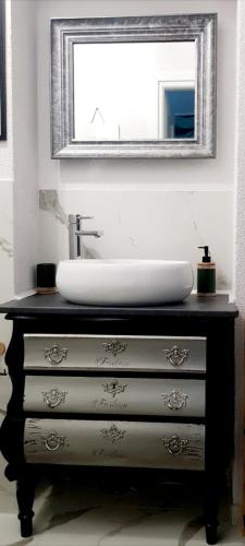 a bathroom with a sink and a mirror on a dresser at Oaza Spokoju in Szczawno-Zdrój