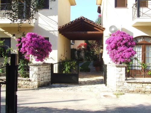 a entrance to a building with purple flowers at Raptis Aparthotel Sivota in Sivota