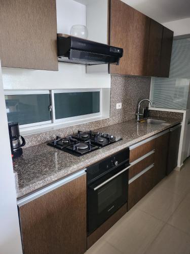 a kitchen with a stove and a counter top at Apto anillo vial cerca Cañaveral in Floridablanca