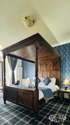 a bedroom with a canopy bed in a room at Royal Marine Hotel Dunoon in Kirn