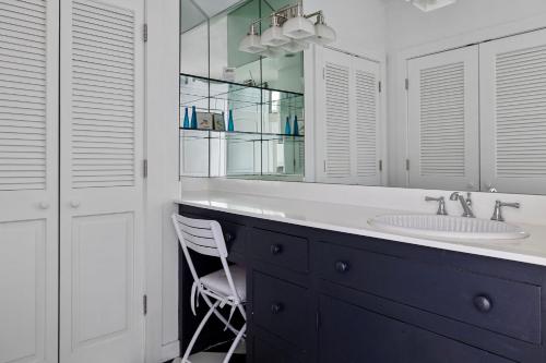 a bathroom with a sink and a mirror and a chair at Rabbit Run in Sawyer