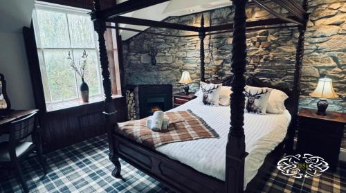 1 dormitorio con cama y pared de piedra en Royal Marine Hotel Dunoon en Kirn