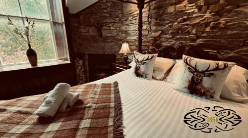 a bedroom with a large bed with a stone wall at Royal Marine Hotel Dunoon in Kirn