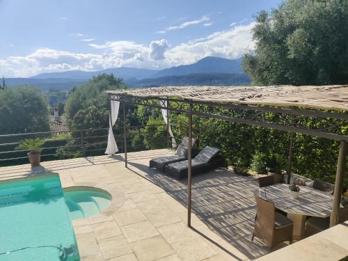 a patio with a table and a swimming pool at Les collines de St Paul in Saint Paul de Vence
