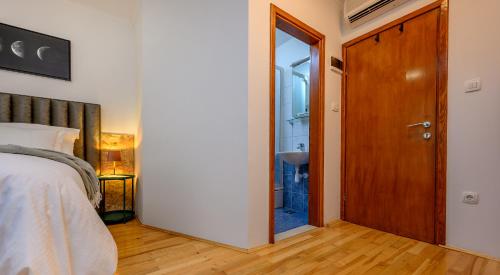 a bedroom with a bed and a wooden door at Yellow house with private parking in Split