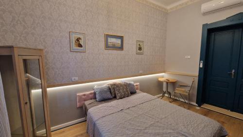 a bedroom with a bed and a blue door at Rose Gardens in Vršac