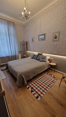 a bedroom with a large bed and a rug at Rose Gardens in Vršac