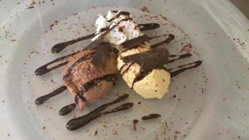 a plate with ice cream and chocolate on it at Hotel Sportalm in Gerlos