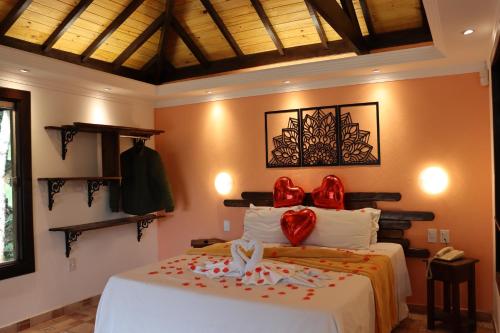 a bedroom with a bed with red bows on it at Pousada Cantinho das Estrelas in Monte Verde