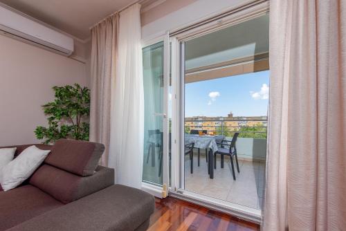 a living room with a couch and a balcony with a table at Apartment Matea with terrace in Zadar