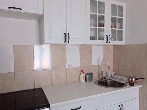 a kitchen with white cabinets and a sink at A part hn in Herceg-Novi