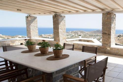 a table on a patio with a view of the ocean at Kapari Home Syros in Vari