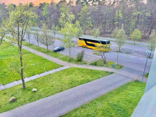 Un autobús amarillo está conduciendo por una calle en Trip Inn Hotel Frankfurt-Heusenstamm, en Heusenstamm