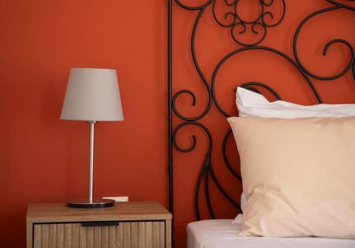a bed with a white pillow and a lamp on a night stand at Kapari Home Syros in Vari