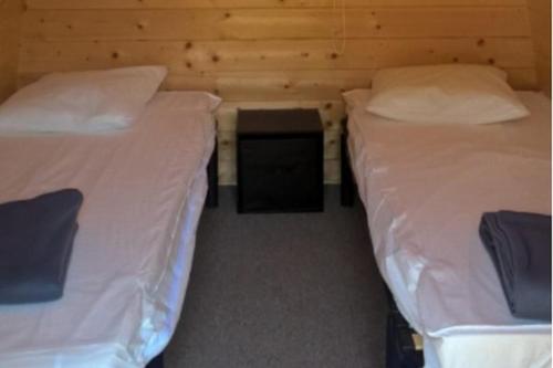 - 2 lits jumeaux dans une chambre avec une table dans l'établissement Camping Onlycamp le Clos Imbert, à Thouars