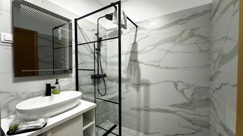 a white bathroom with a sink and a shower at AD Apartments in Cluj-Napoca