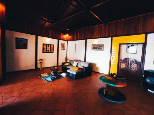 a living room with a couch and a table at La Villa Mil'Or, Idéale pour vos petits évènements & Magnifique vue sur la Baie du Robert in Le Robert