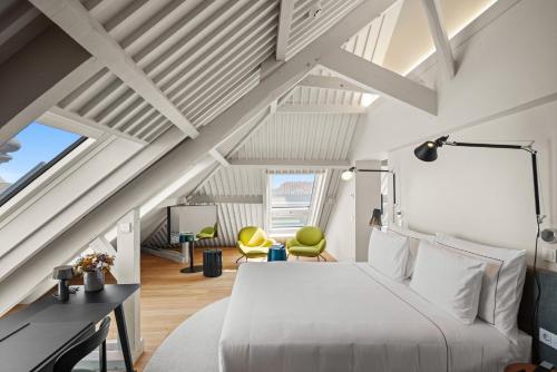 a bedroom with a white bed and yellow chairs at The Lince Santa Clara in Vila do Conde