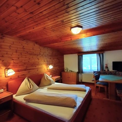a bedroom with two beds in a wooden room at Pension Andrea in Fusch an der Glocknerstraße