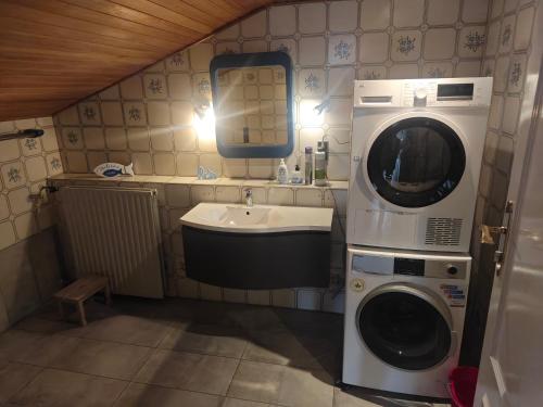 een kleine badkamer met een wasmachine en een wastafel bij Work and Stay 8 Betten 1 Küche 1 Badezimmer 150qm in Geilenkirchen