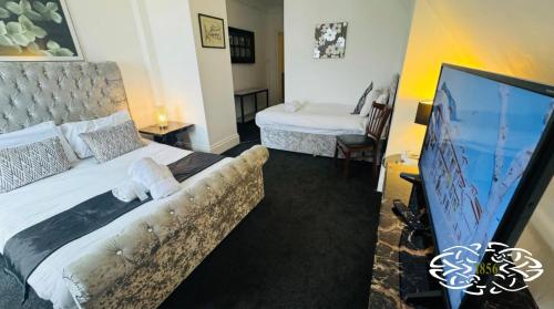 a bedroom with a bed with a couch and a tv at Royal Marine Hotel Dunoon in Kirn