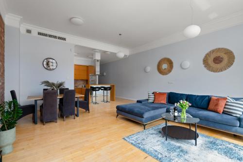 a living room with a blue couch and a table at AS HOME Apartamenty Rynek 50 R503 Amazing View in Wrocław