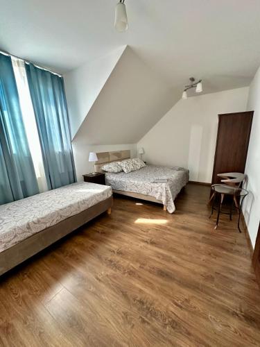 a bedroom with two beds and a table in it at Rodart Morski in Sztutowo