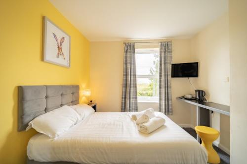 sypialnia z łóżkiem z dwoma ręcznikami w obiekcie The Well Inn w mieście Shepton Mallet