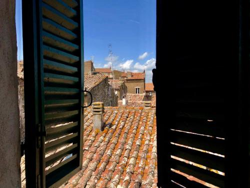 an open door with a view of a tile roof at B&B Dimor'à in Pitigliano