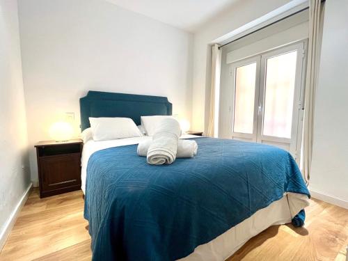1 dormitorio con 1 cama grande con manta azul en Exclusive Apartment in Historic Center, en Madrid