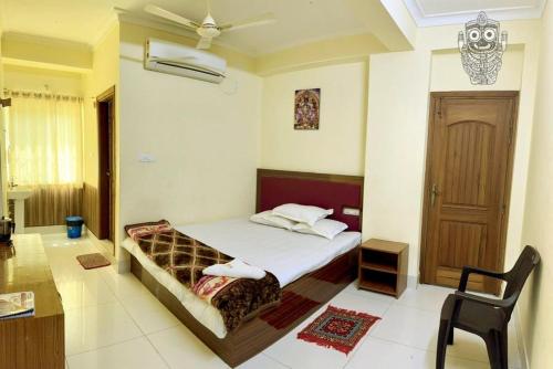 a bedroom with a bed and a chair in a room at Jagannath Palace in mayapur