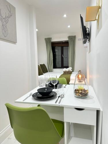 a white table with a plate of food and wine glasses at Tower Bridge Studios in London