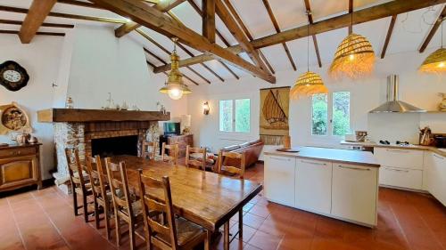 Il comprend une cuisine et une salle à manger avec une table et une cheminée. dans l'établissement Villa Familiale - Golfe de Saint Tropez, à Grimaud