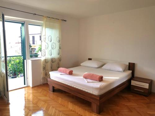 um quarto com uma cama com duas toalhas cor-de-rosa em Apartmani Rudelj em Makarska