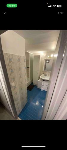 a bathroom with a hallway with a blue floor at Studio plein coeur station Orcieres les merlettes in Orcières