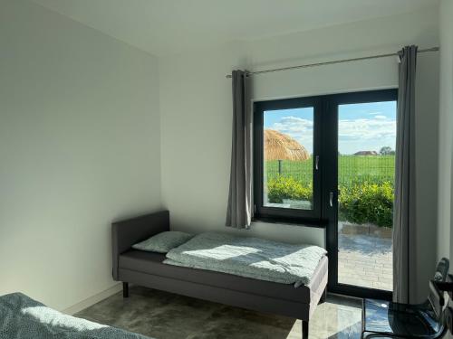a bedroom with a bed and a window at Kamyczek in Gąski