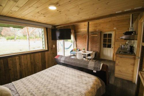 a bedroom with a bed and a table in a room at Hostal Dos Volcanes in Malalcahuello