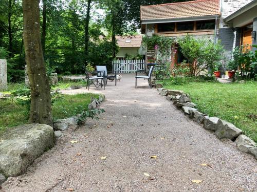 a patio with two benches in front of a house at Chambre sur une ile in Saint-Bonnet-de-Rochefort