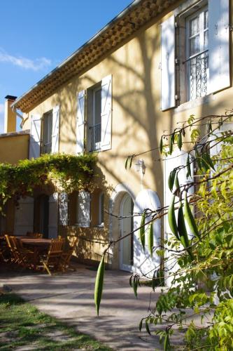 un bâtiment avec une table et des chaises devant lui dans l'établissement MOULIN SAINT ETIENNE, à Bédarieux