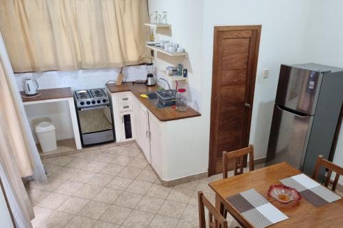 a small kitchen with a refrigerator and a table at Boulevard 251 Riverside Apartments in Iquitos