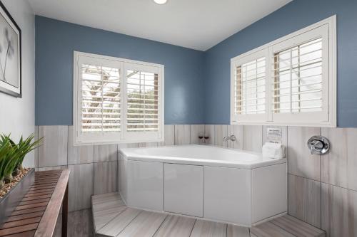uma casa de banho com uma banheira branca e 2 janelas em Candle Light Inn em Carmel