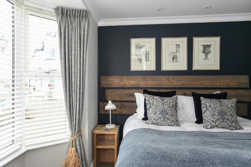 1 dormitorio con 1 cama con cabecero de madera en Marners Rock No 1 en Fowey