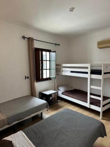 a bedroom with two bunk beds and a window at Casa da Moura in Moura