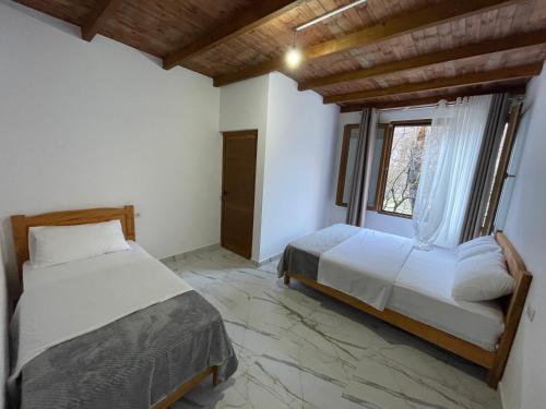 a bedroom with two beds and a window at xhovani zelna in Shkodër